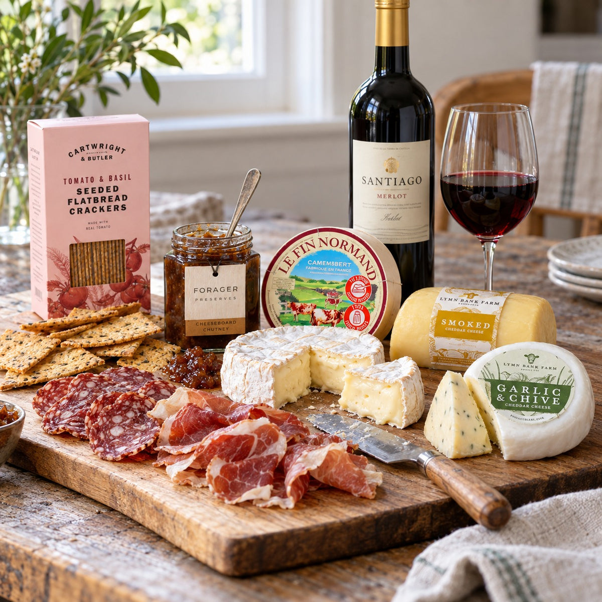 The Banquet Hamper: Camembert, smoked cheddar, garlic and chive cheddar, charcuterie, chutney, crackers and Santiago Merlot