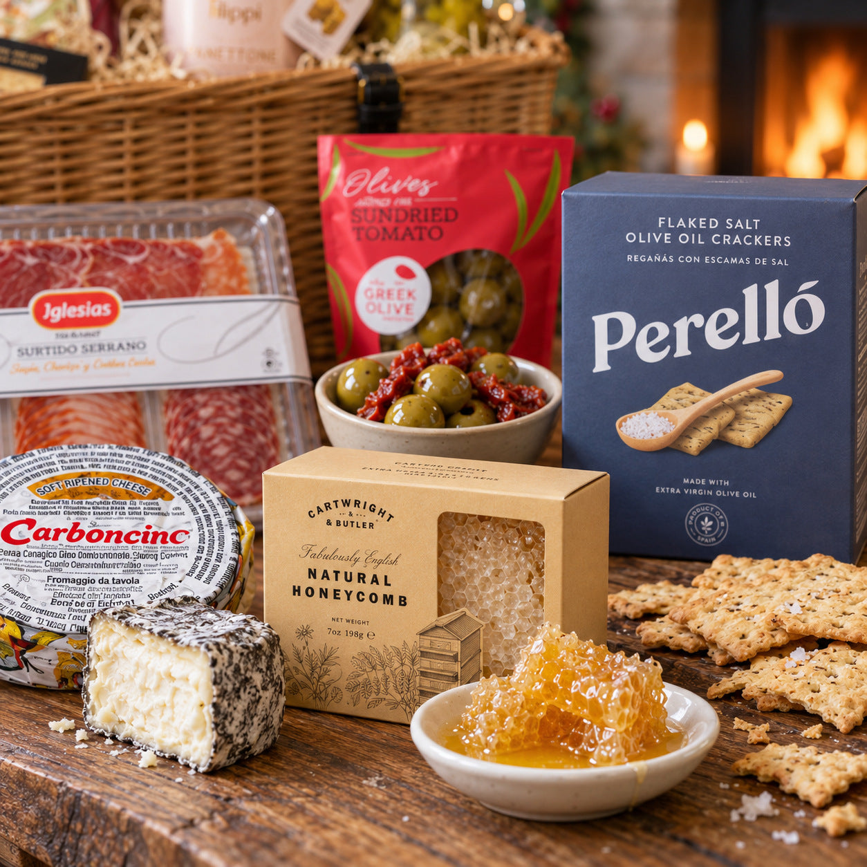 Detail from A Mediterranean Christmas: Cartwright & Butler honeycomb on a small plate, stuffed olives in a bowl, Perelló crackers and the Carboncino cheese cut open. This shows part of the hamper; tableware is not included.